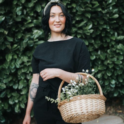 Cassidy Moss holding a basket of freshly harvested herbs