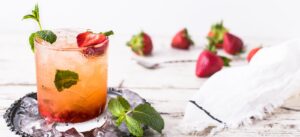 glass of mint and strawberry beverage on brown panel