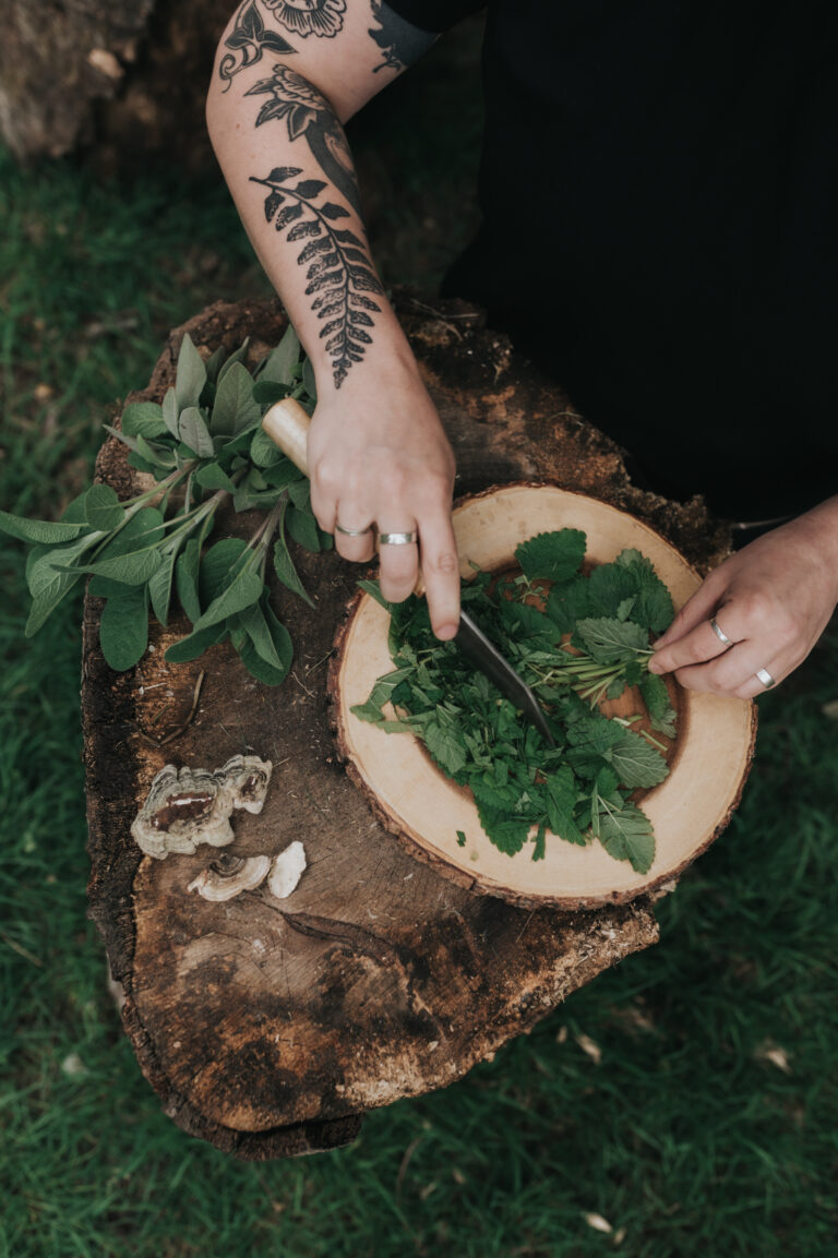 Hands sorting fresh greens on a wooden board
