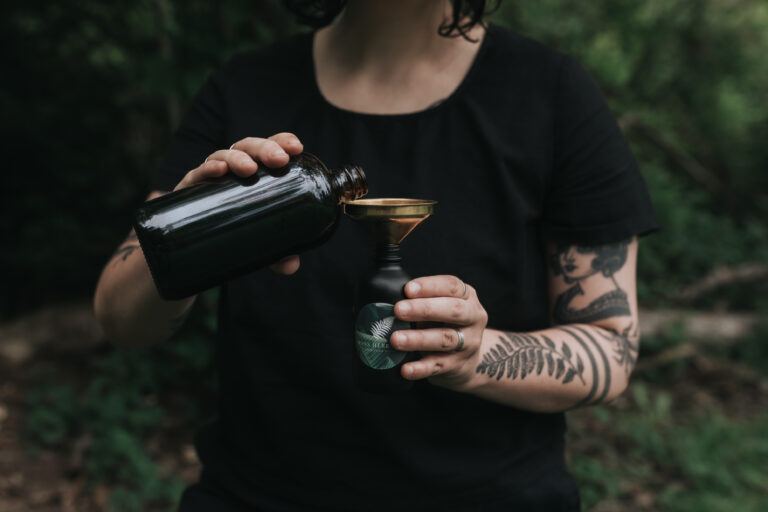 Pouring a tincture into a small glass