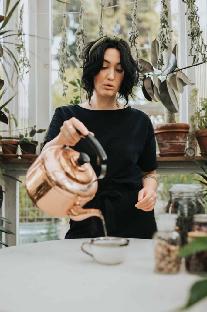 Cassidy Moss preparing medicinal herbs, demonstrating how to steep loose leaf herbal tea for clinical herbalism use