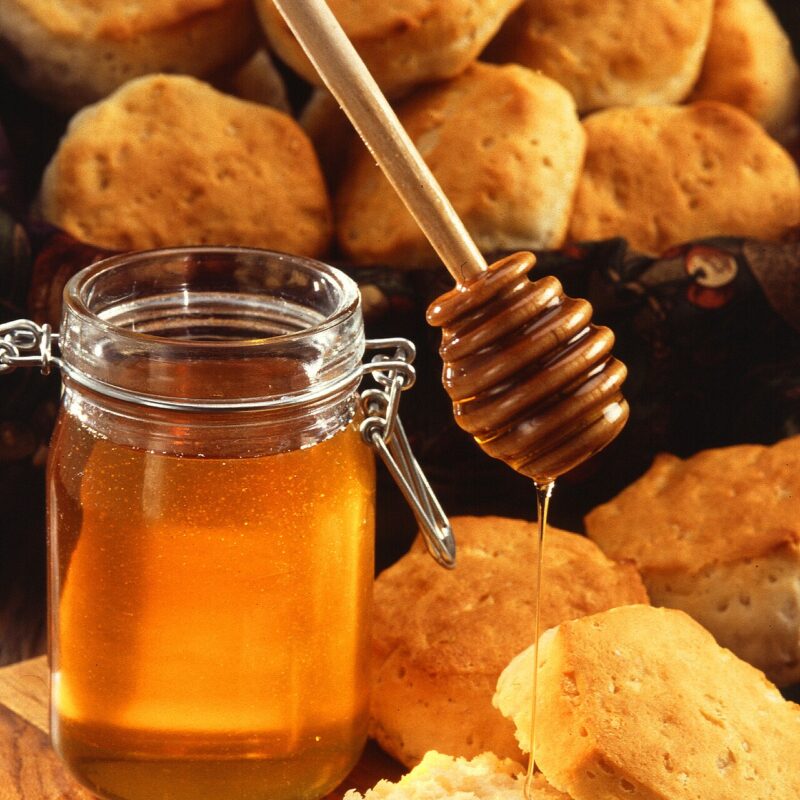 Jar of honey with a wooden honey dipper